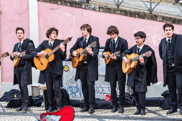 Foto de alunos da Universidade de Coimbra em Portugal a tocar e cantar música tradicional nas ruas históricas da cidade