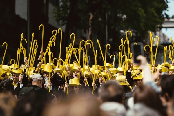 Foto do desfile da Queima das Fitas do Porto. Festa anual dos estudantes universitários portugueses. Os formandos usam cartola e bengala, ambos da cor da Faculdade.